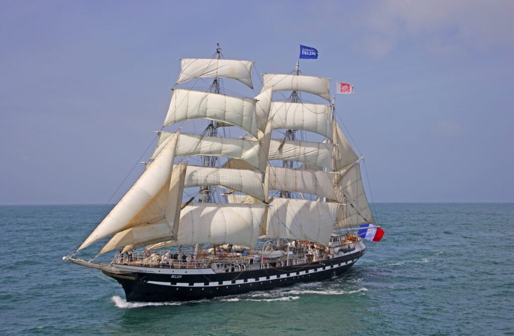 Le Belem, majestueux trois-mâts français du XIXe siècle, naviguant élégamment en mer, symbole de l'histoire maritime et du patrimoine français.