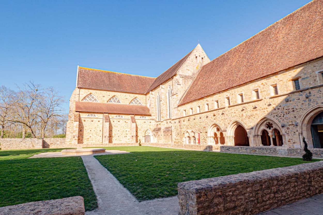 Vue ensoleillée de l'Abbaye Royale de l'Épau en Sarthe, magnifique monument historique cistercien, reflétant l'histoire et la culture française.